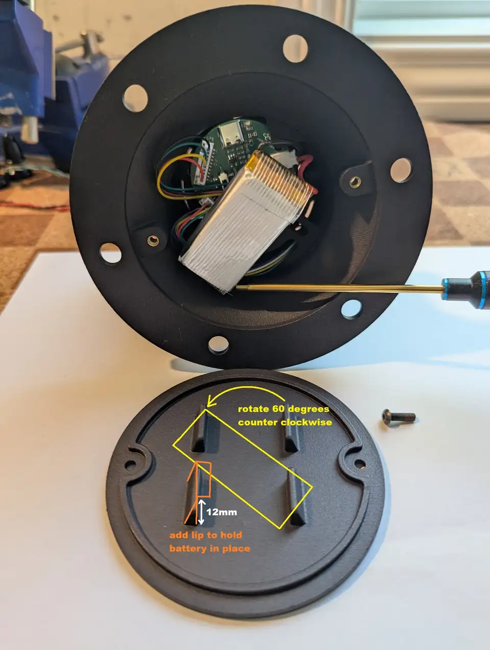 A printed electronics enclosure opened up and annotated with design changes, such as adding a lip to hold the battery.